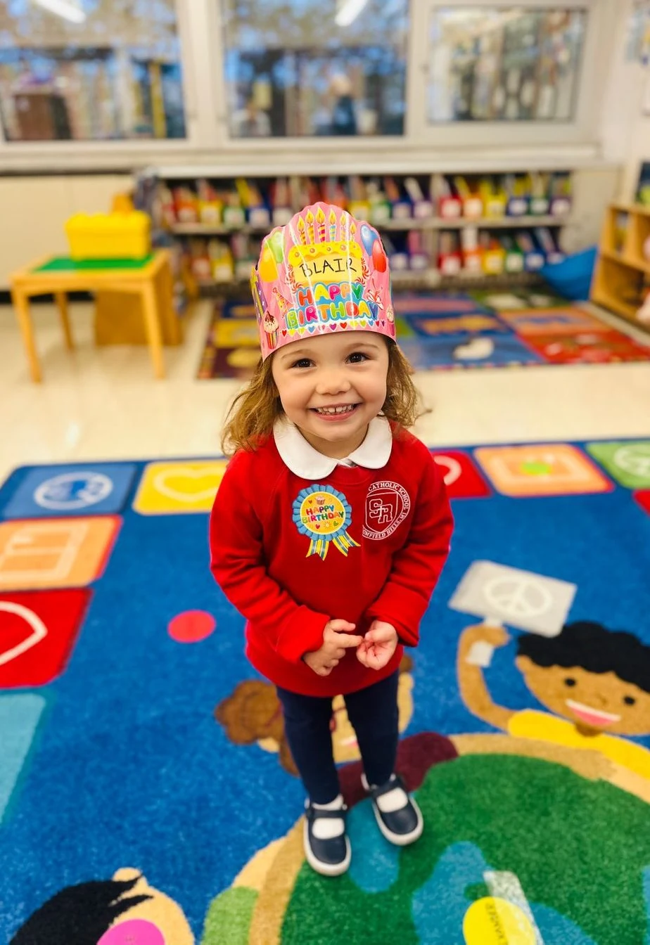 Preschool student wearing a paper crown in the classroom
