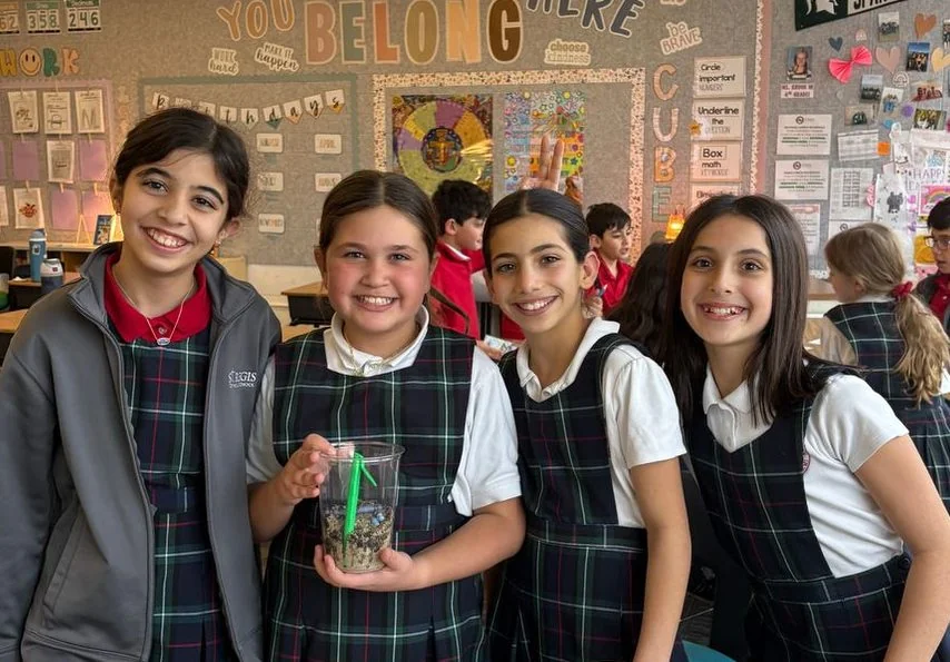 Students in uniform smiling together in their classroom