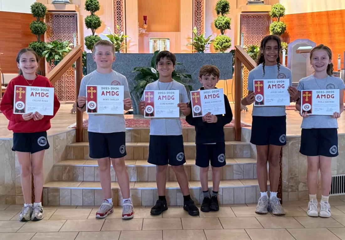 Students holding award certificates at the front of the church