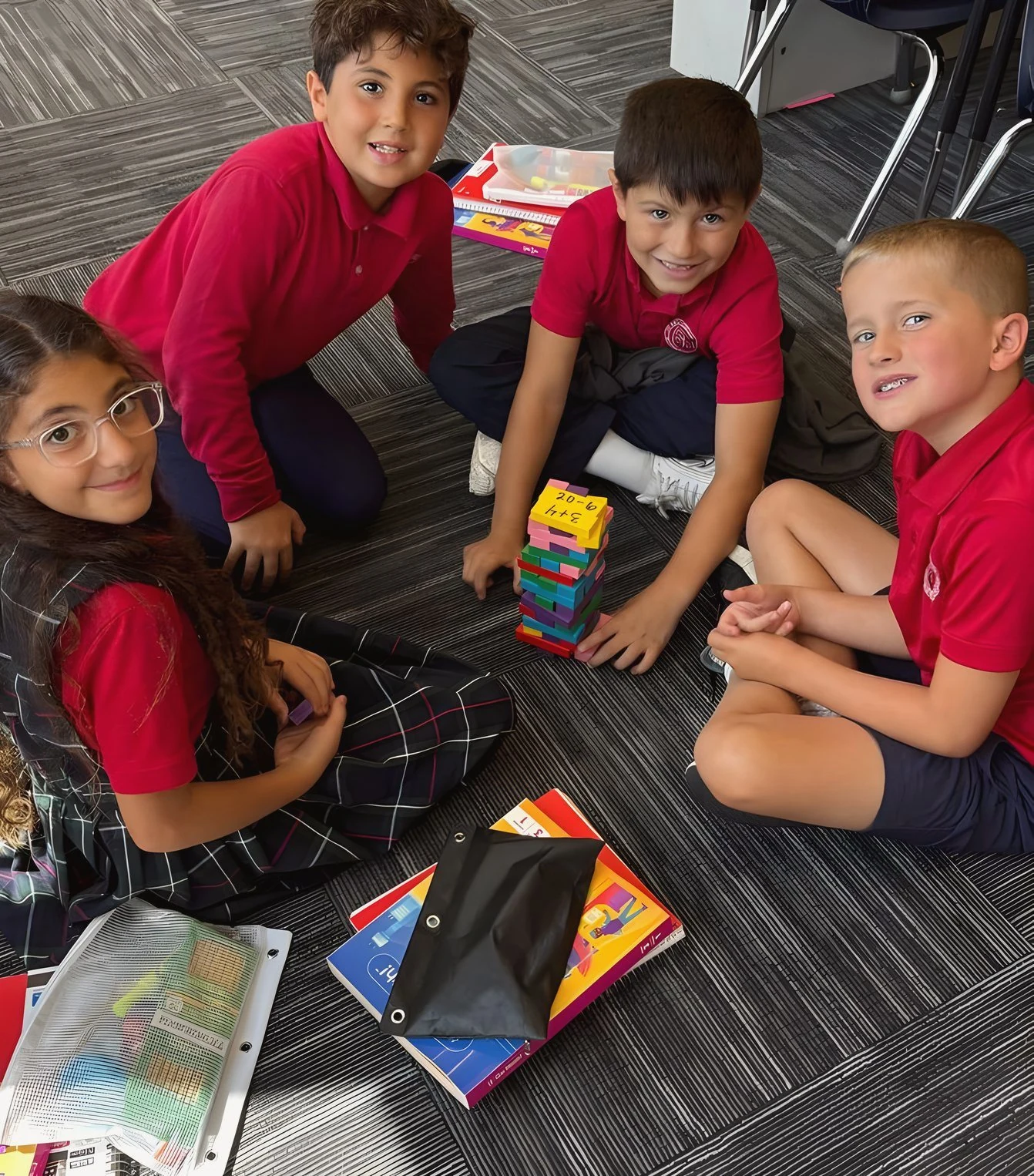 Students playing a block-stacking game on the classroom floor