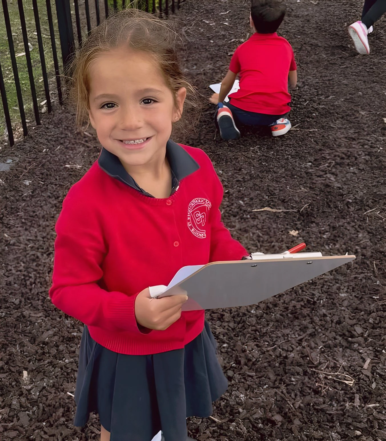 Young student holding a clipboard on the playground