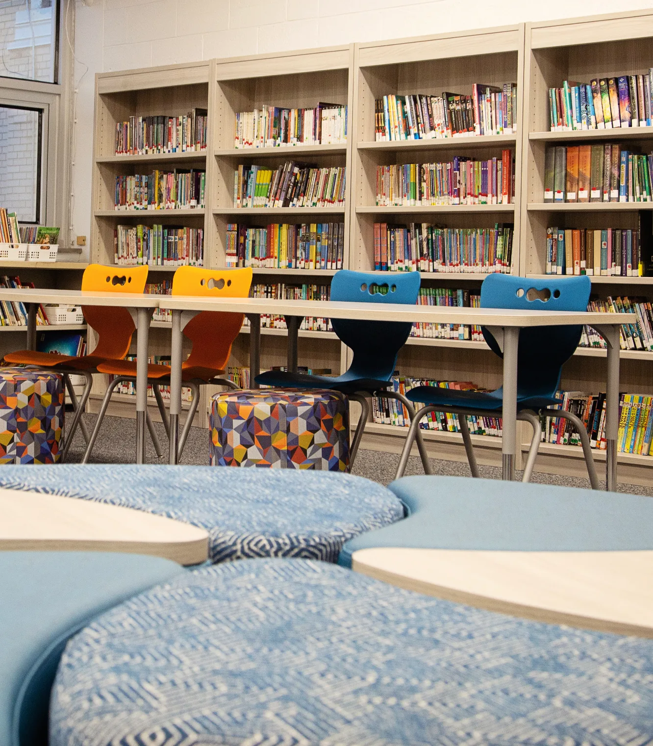 School library with bookshelves, tables and soft seating
