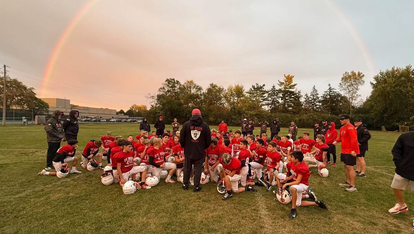 St. Regis football team on the field under a rainbow