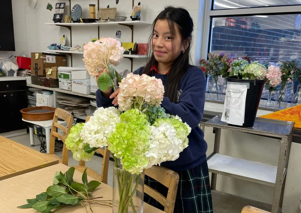 Student arranging flowers in a vase