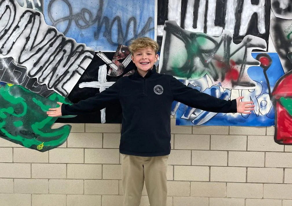 Student in front of a graffiti-style mural