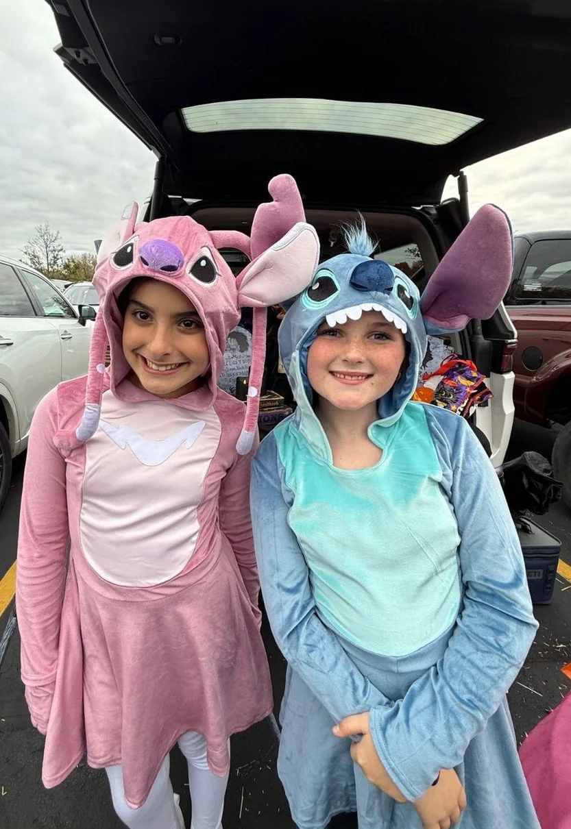 Two students in costumes at a trunk-or-treat