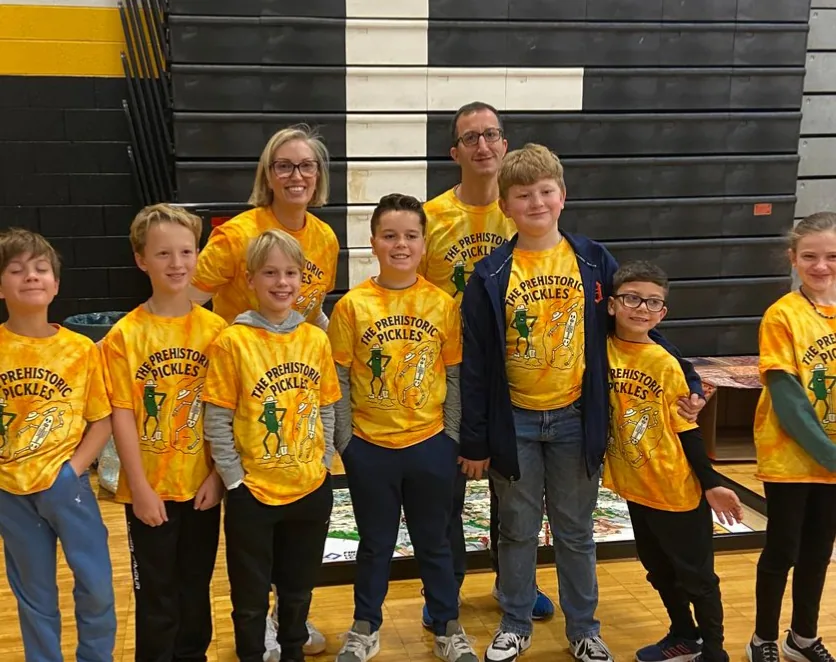 Students and teachers in matching team T-shirts in the gym