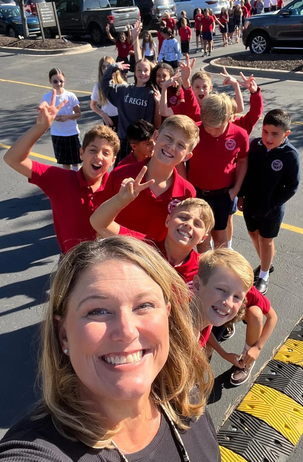 Teacher taking a selfie with smiling students outside