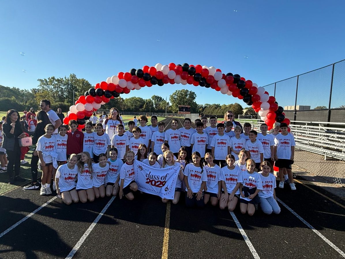 Students under a balloon arch at the St. Regis Fun Run