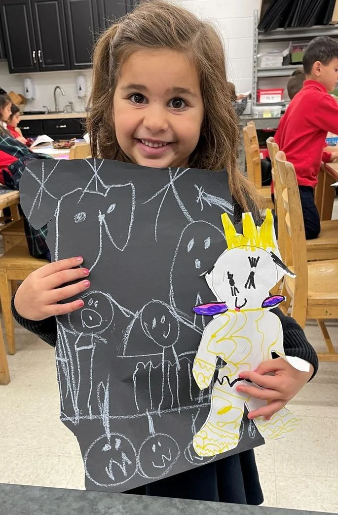 Young student holding up her artwork
