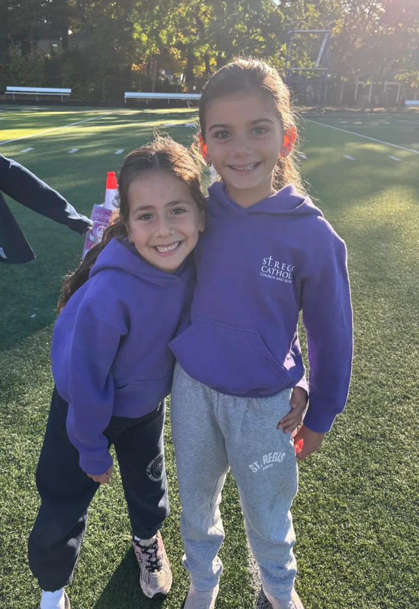 Two students in house T-shirts on the field