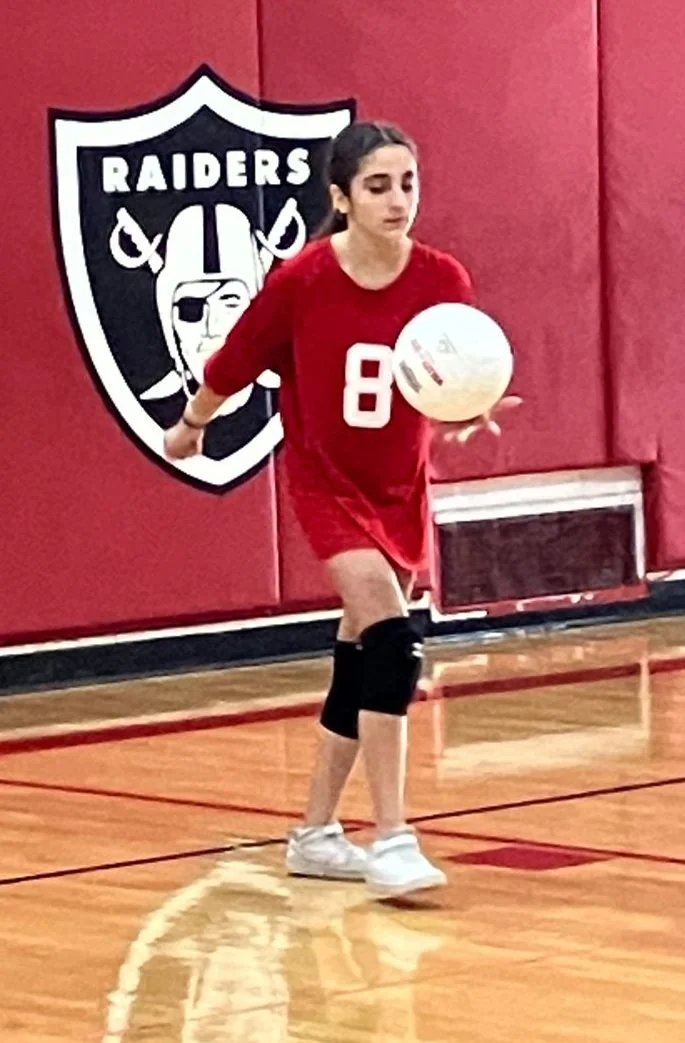 St. Regis volleyball player with a ball in the gym