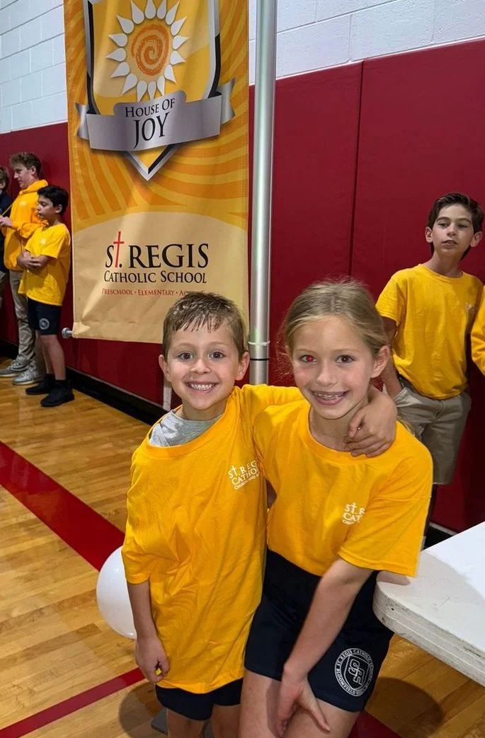 Two students in House of Joy shirts in the gym