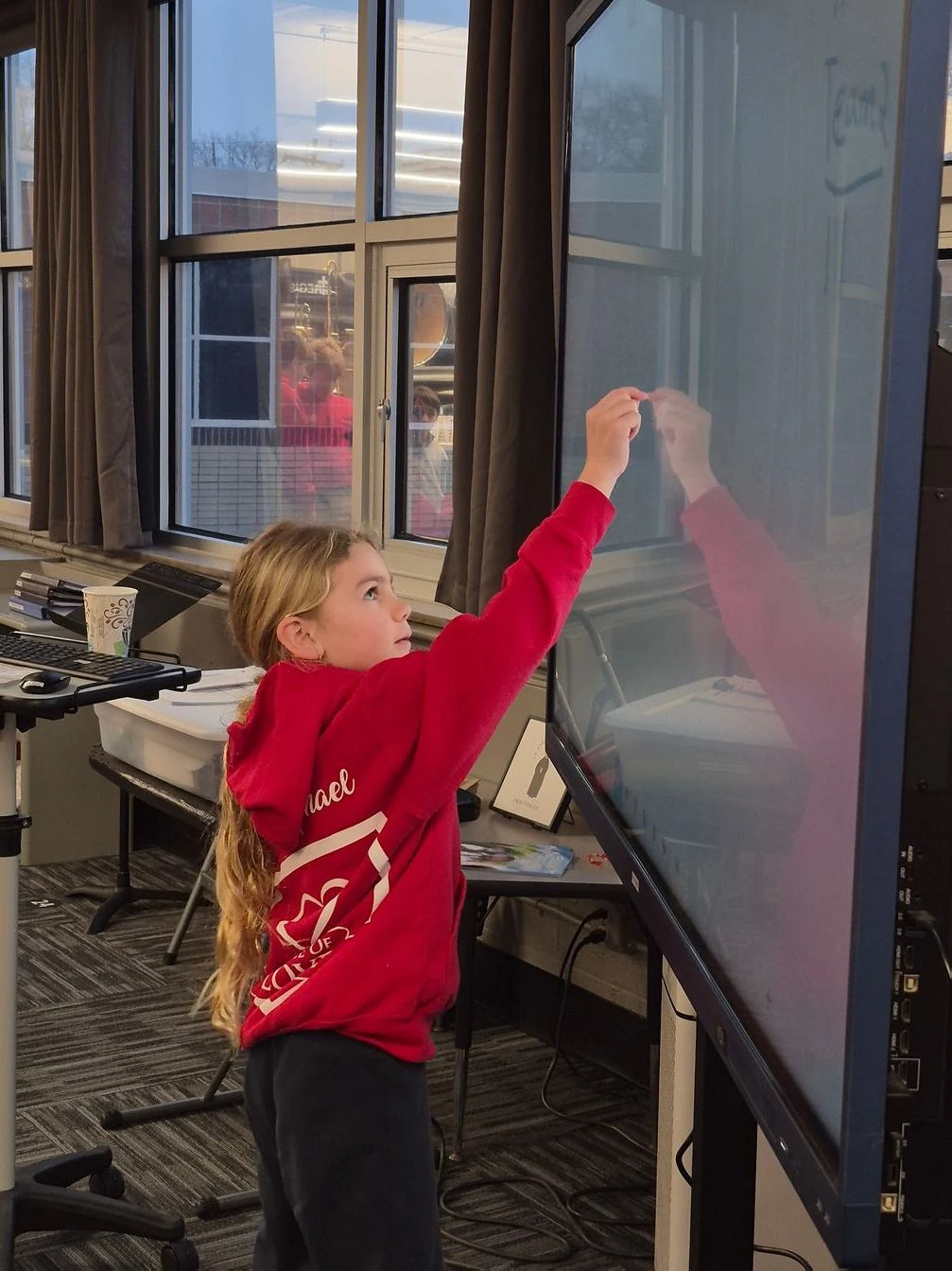 Student writing on a classroom smart board