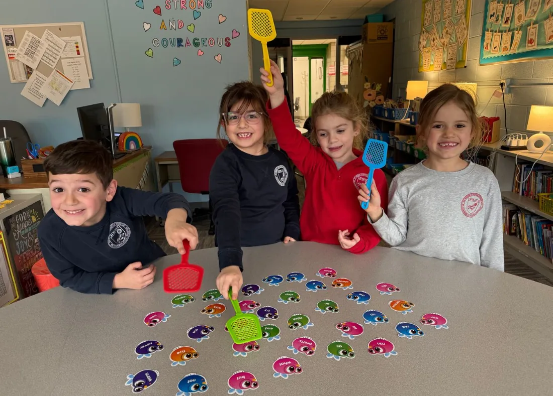 Young students playing a learning game with fly swatters