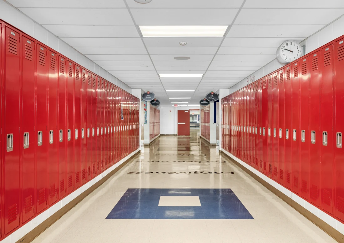 School hallway lined with red lockers