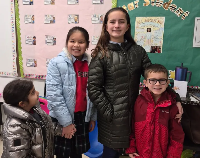 St. Regis students together in front of a classroom bulletin board