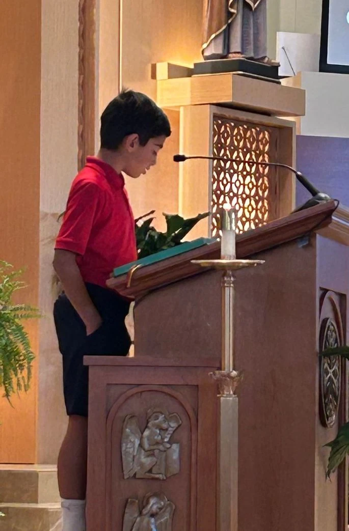 Student reading at the lectern during Mass