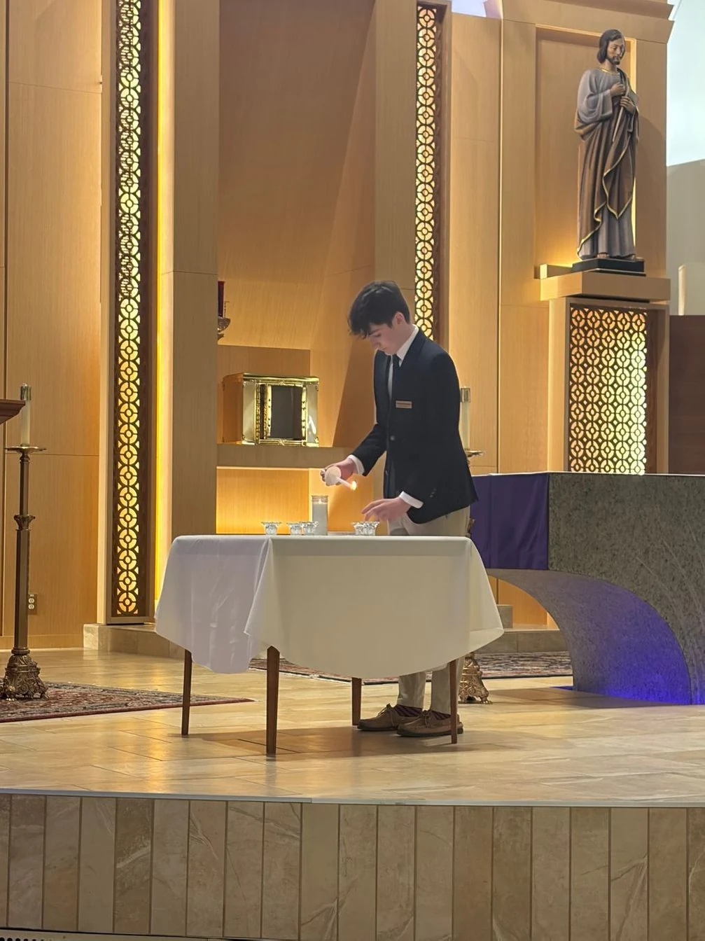 Student serving at the altar in church