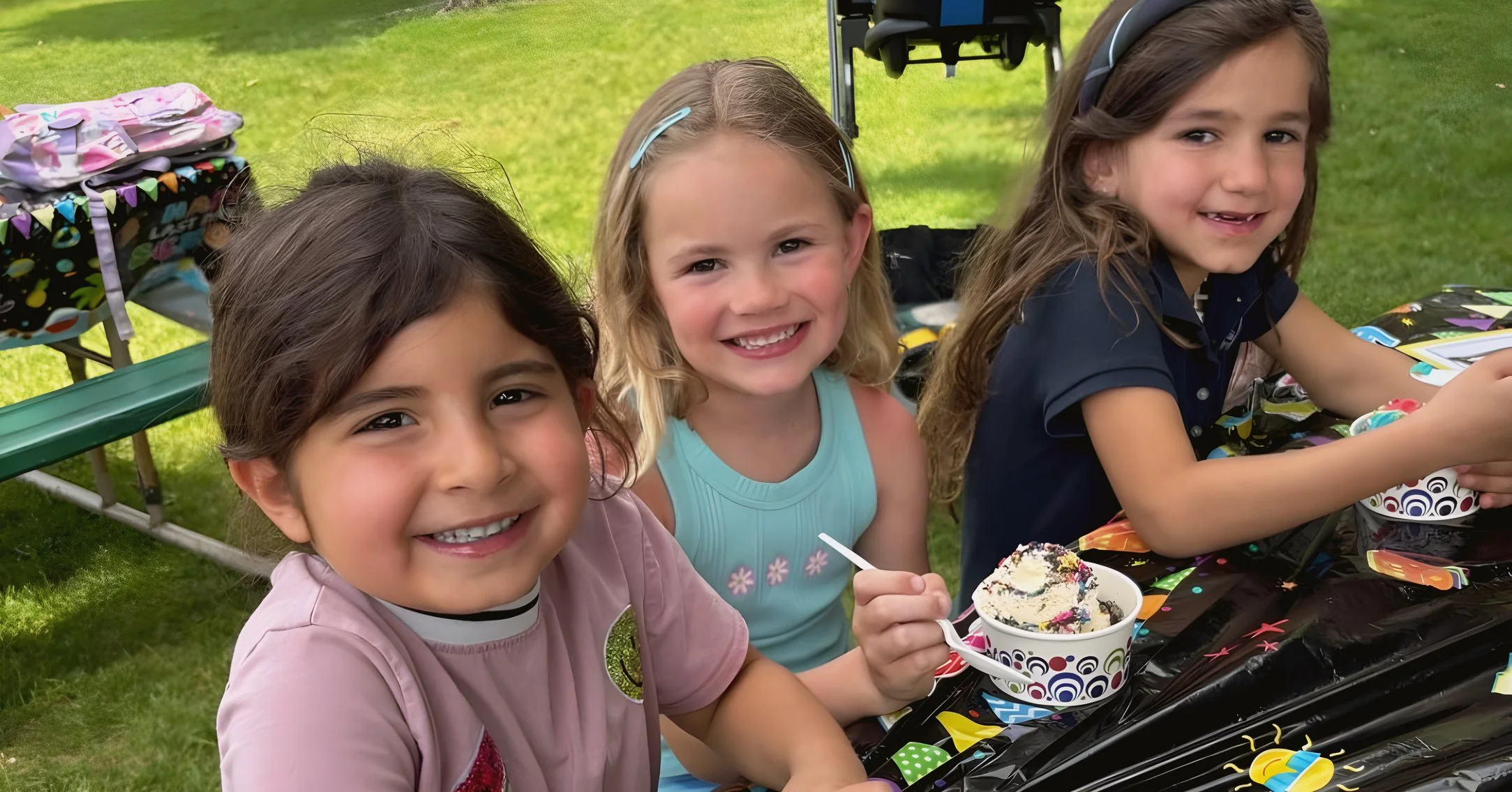 Young students decorating an art project outdoors