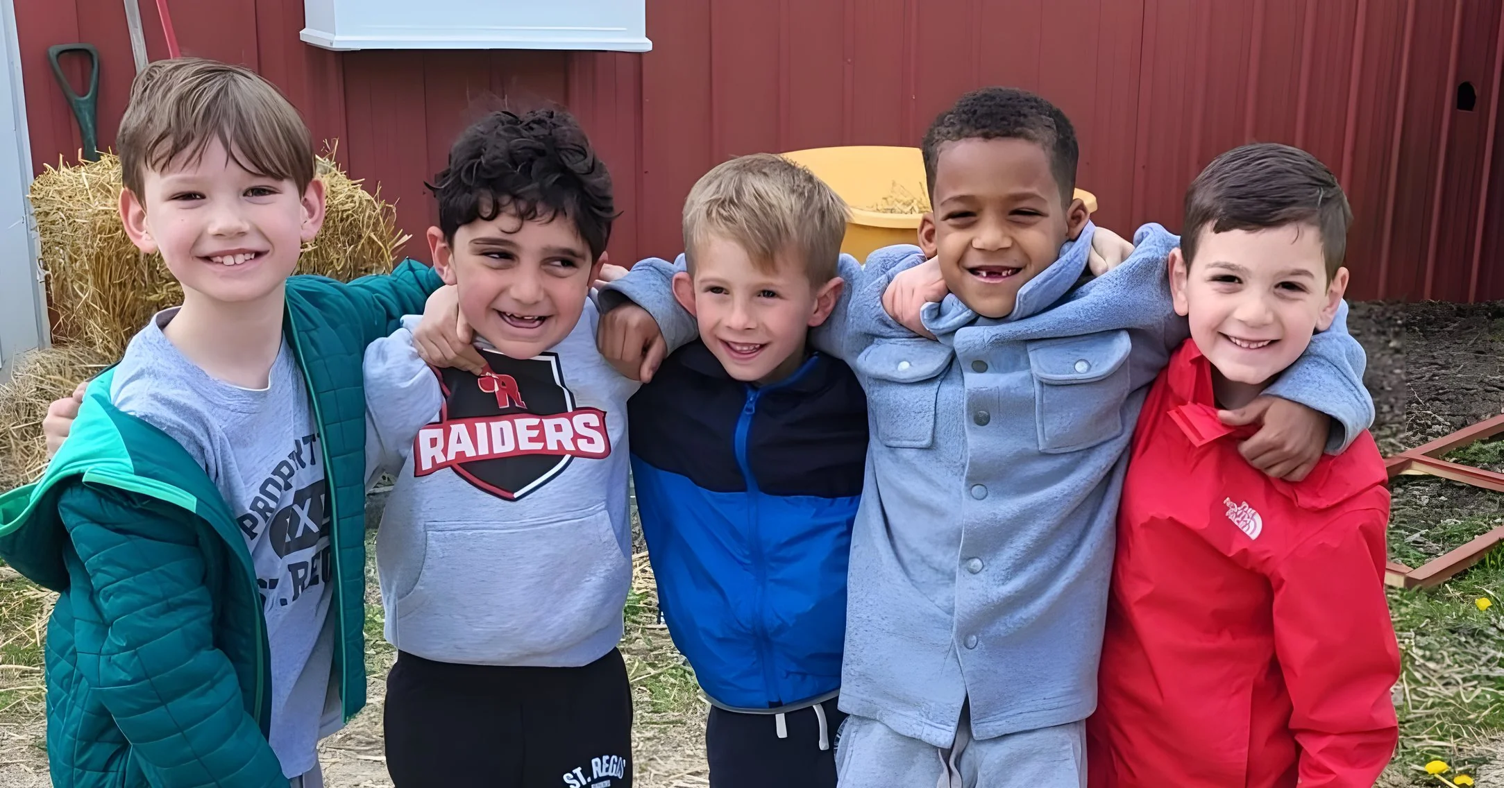 Group of young students with arms around each other outdoors