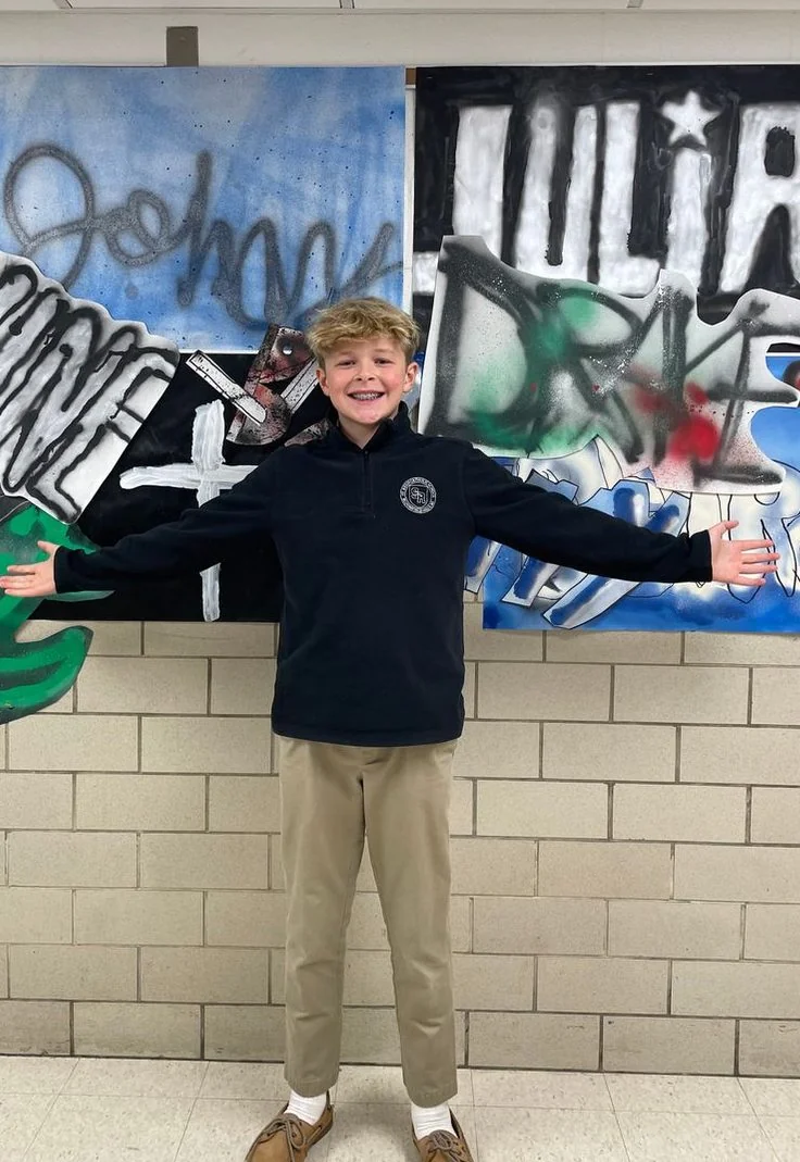 Student in front of a graffiti-style mural
