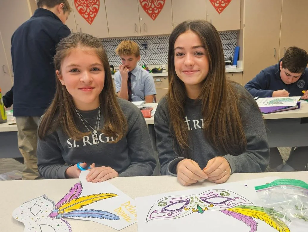 Two students decorating masks in art class